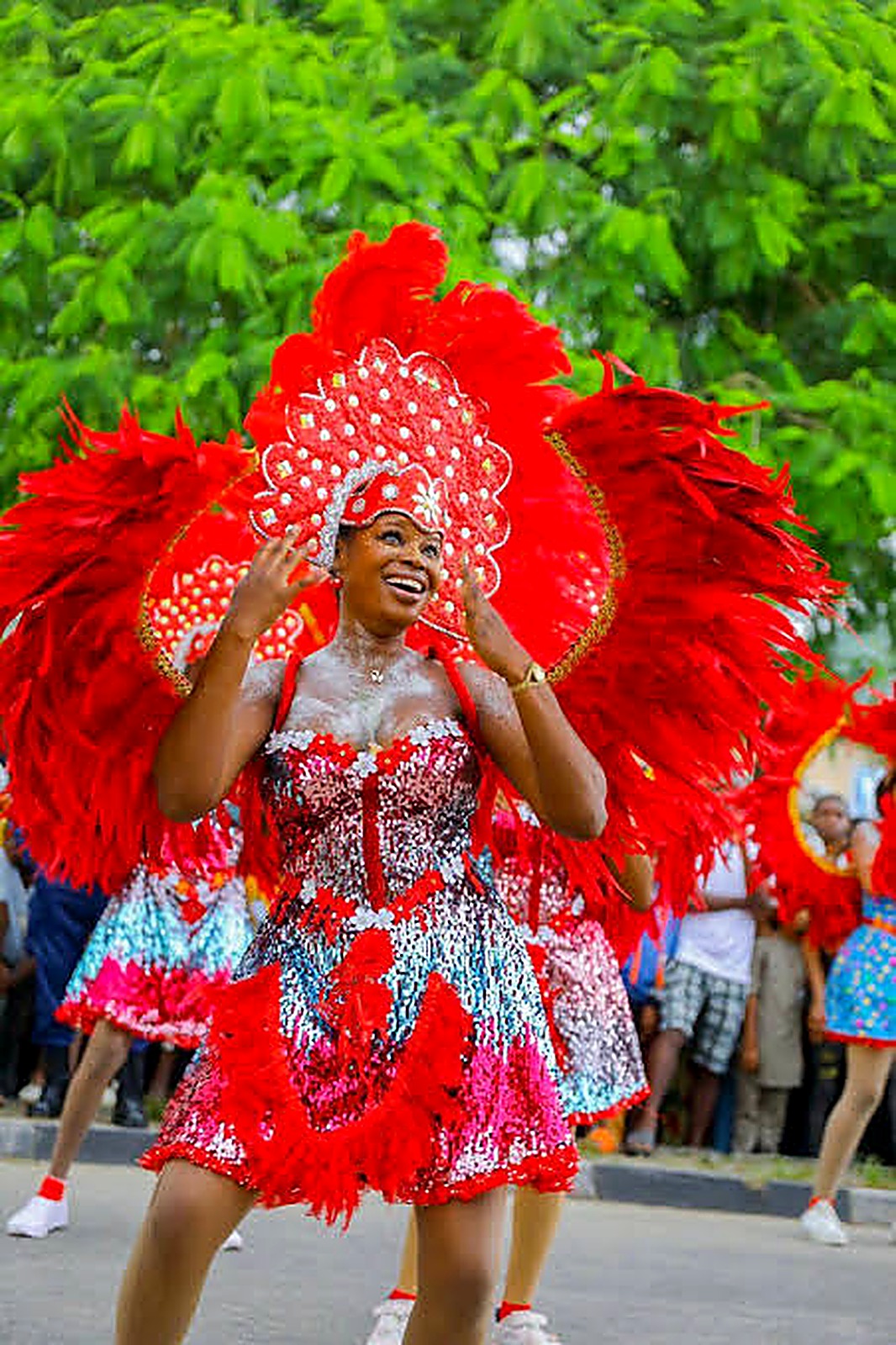 Smiling performer in winged red feather costume