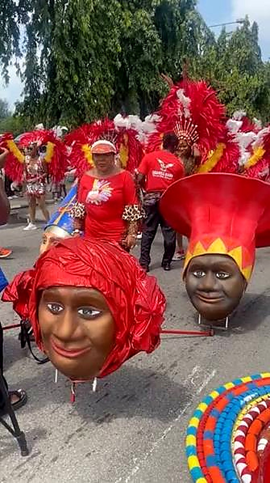 Oversized carnival head sculptures beside performers