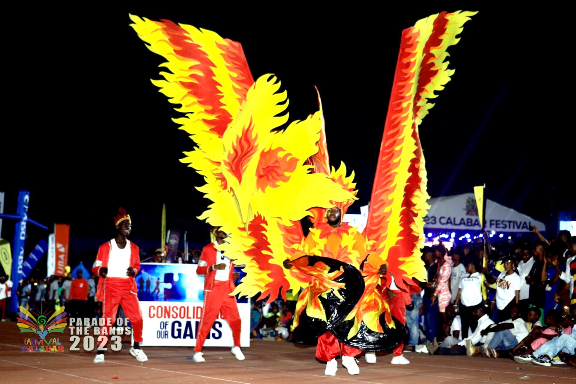 Performer with golden flame wings on the night stage