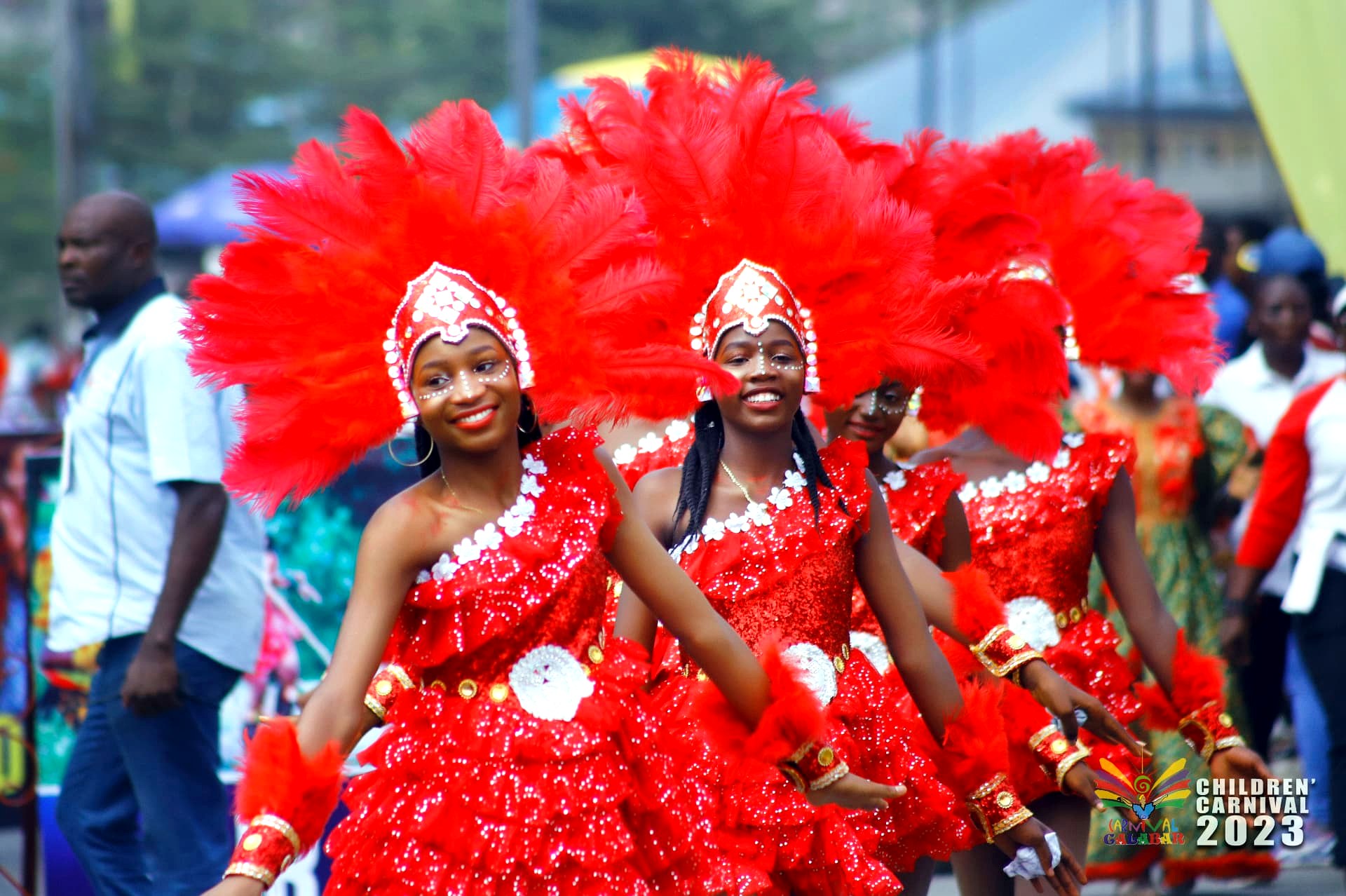 Dancers in sequinned crimson dresses on the parade route