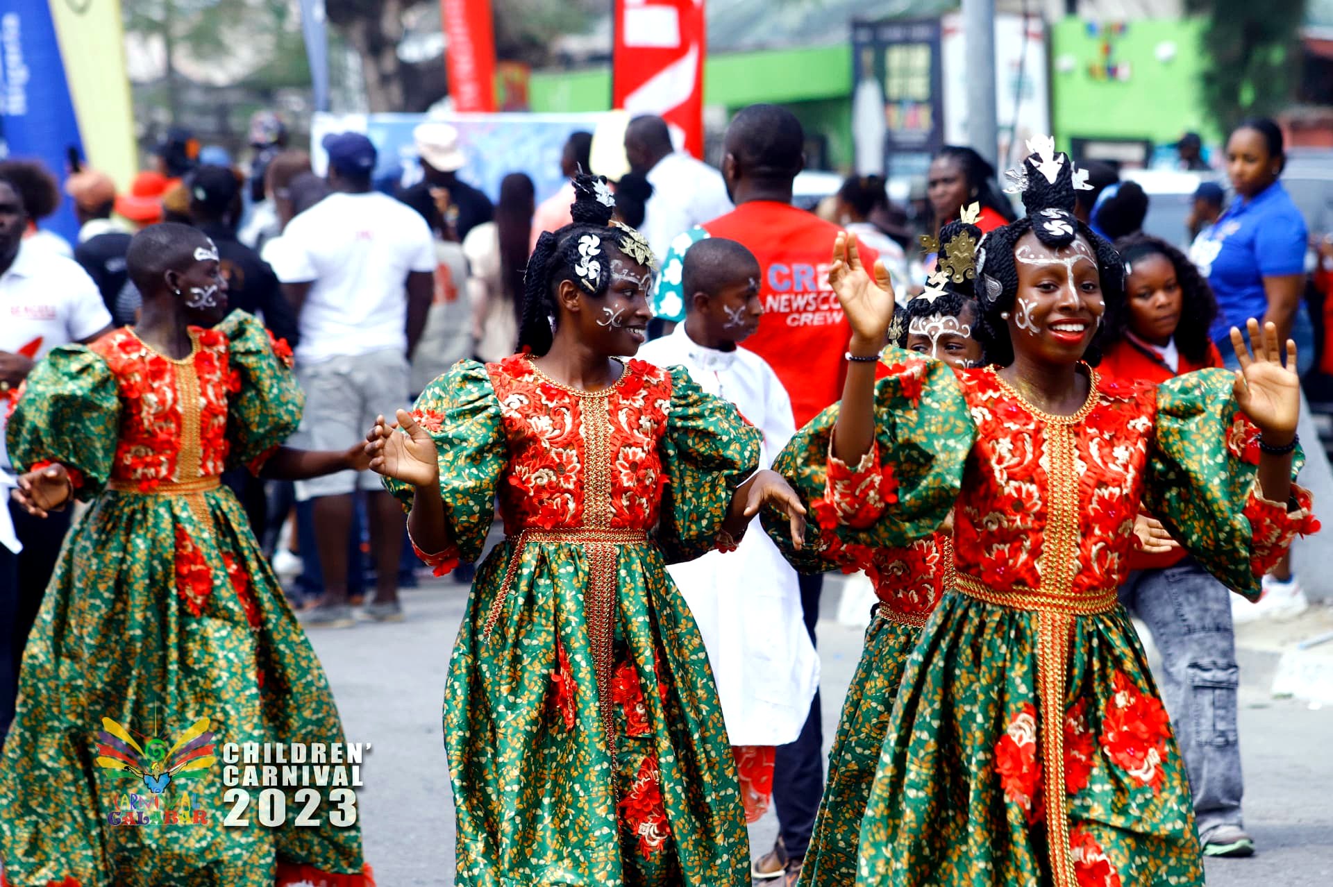 Dancers in traditional green and crimson dresses