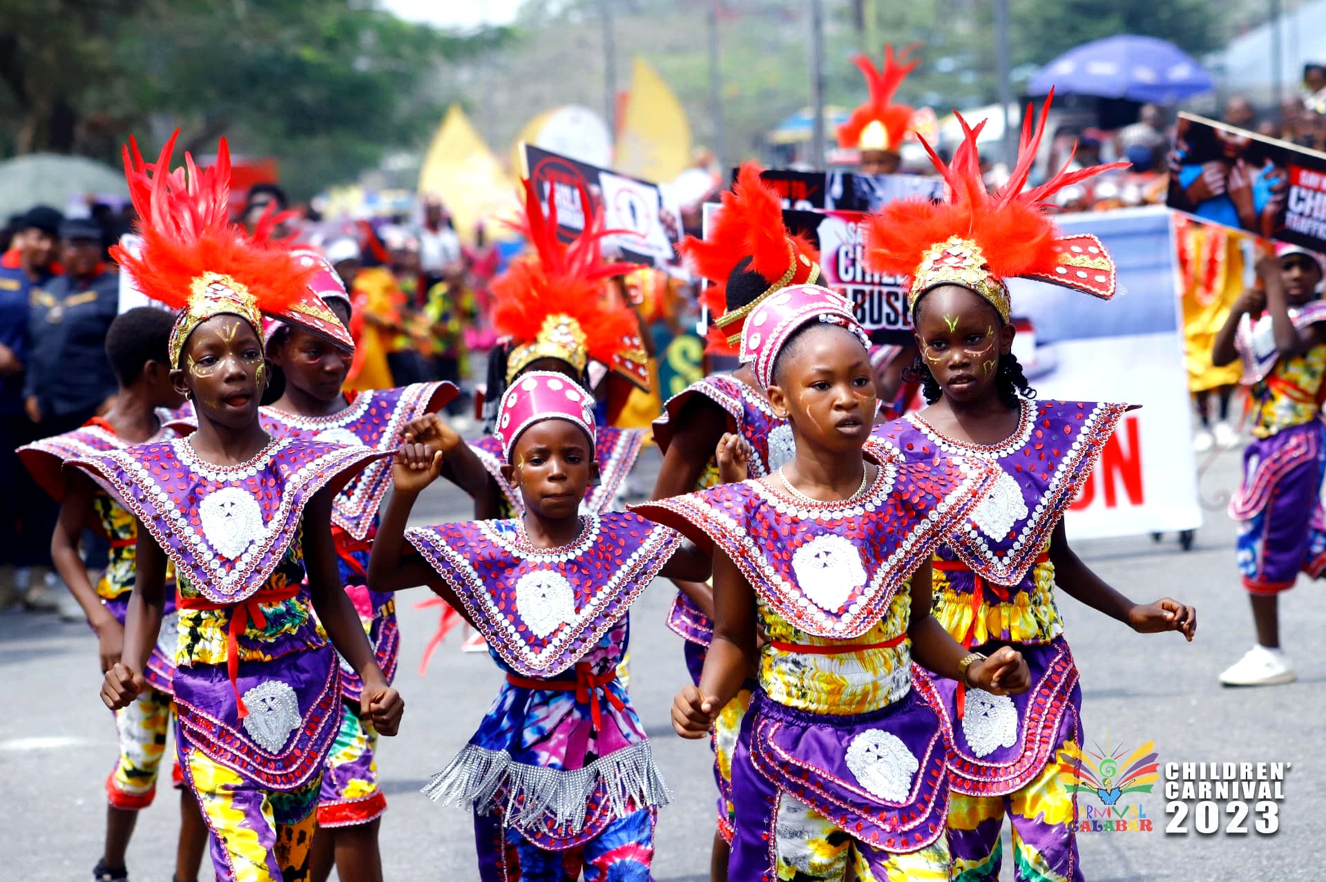 Young performers in violet and gold marching the route